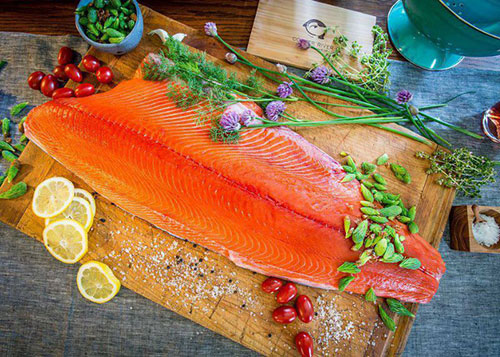 Salmon Recipes - Salmon Filet on Cutting Board with Fruit and Herbs